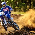 Rating of the best motocross motorcycles - in the picture, a man in a motocross racing uniform races on a section of a motocross track